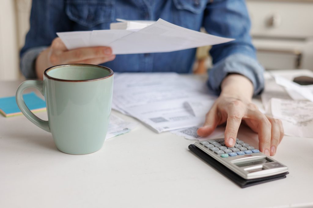 calculation of social payments of maternity or alimony. sad woman pays bills